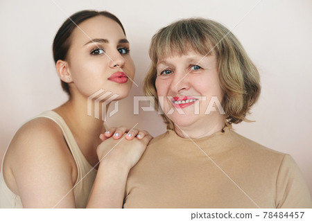 Mother and daughter over beige background 78484457