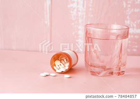white color medical pills spilling on pink white color medical pills spilling on pink 78484857