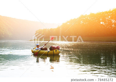 Tourist on yellow packraft rubber boat with red padle 78485272