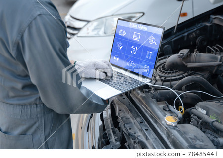 Mechanic using a laptop computer to check collect information during work a car engine. service maintenance of industrial to engine repair. Mechanic using a laptop computer to check collect information during work a car engine. service maintenance of industrial to engine repair. 78485441