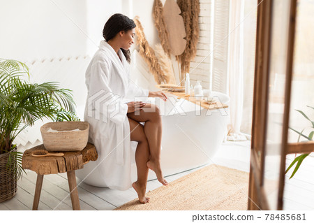 Black Female Preparing Bath Adding Bathing Salt Sitting In Bathroom Black Female Preparing Bath Adding Bathing Salt Sitting In Bathroom 78485681