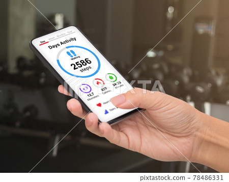 Unrecognizable woman checking daily activity while exercising at gym 78486331