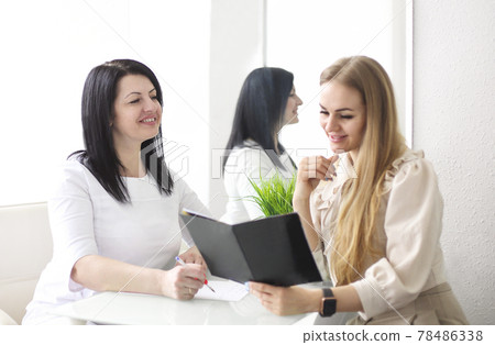 Smiling woman talking to beautician in salon 78486338