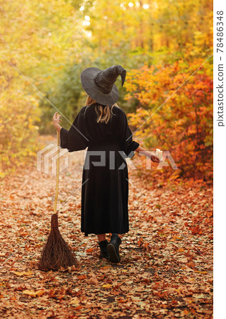 Unrecognizable witch walking in autumn forest 78486348