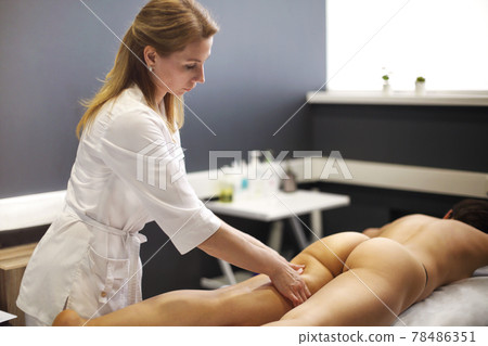 Hands of Masseur kneading female hip 78486351