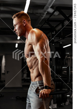 Closeup portrait of a muscular man workout with barbell at gym. Brutal bodybuilder athletic man with six pack, perfect abs, shoulders, biceps, triceps and chest 78487343