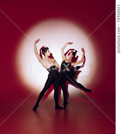 Ballet dancers dancing over red studio background. Modern design. Contemporary colorful conceptual light as rising sun at Japan. Ballet dancers dancing over red studio background. Modern design. Contemporary colorful conceptual light as rising sun at Japan. 78488021