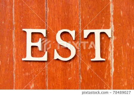 Alphabet letter in word EST  (abbreviation of established, estimated, eastern time zone, expressed sequence tag) on old red color wood plate background 78489027