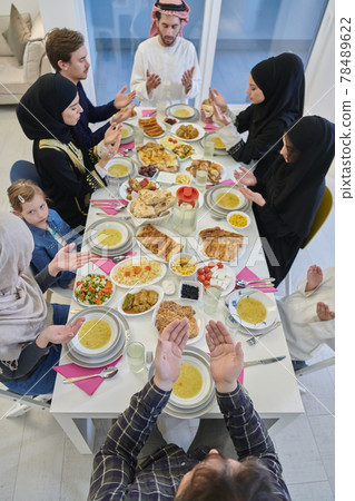 Muslim family making iftar dua to break fasting during Ramadan. Muslim family making iftar dua to break fasting during Ramadan. 78489622