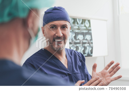 Orthopedist doctor team examining digital X-ray picture in clinic or hospital Orthopedist doctor team examining digital X-ray picture in clinic or hospital 78490308