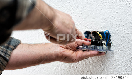 Electrician at work on a residential electrical system. Electricity. Electrician at work on a residential electrical system. Electricity. 78490844