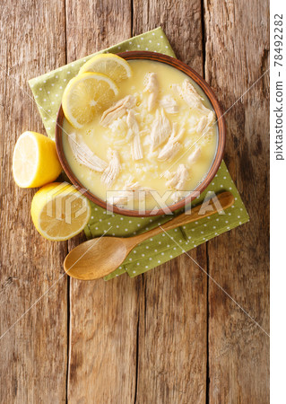 Kotosoupa is a delicious and hearty Greek chicken soup closeup in the plate. Vertical top view Kotosoupa is a delicious and hearty Greek chicken soup closeup in the plate. Vertical top view 78492282