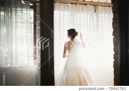 Gorgeous bride in robe posing and preparing for the wedding ceremony face in a room 78492761