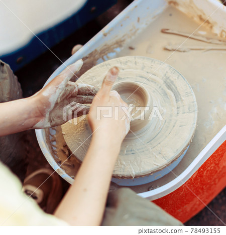 The hands of a master potter create a shape like a mug The hands of a master potter create a shape like a mug 78493155