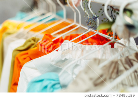 Light craft vintage summer dresses hanging on hangers in the store 78493189