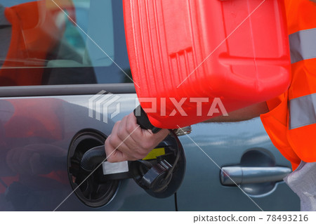 Driver fills the fuel in an empty car tank from canister. Driver fills the fuel in an empty car tank from canister. 78493216