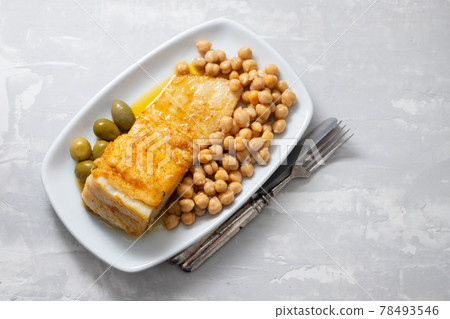 fried cod fish with chick pea and olives on white dish on ceramic background fried cod fish with chick pea and olives on white dish on ceramic background 78493546