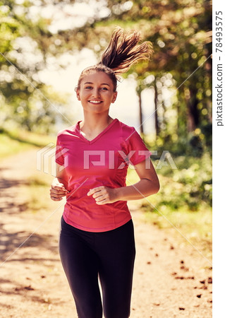 woman enjoying in a healthy lifestyle while jogging woman enjoying in a healthy lifestyle while jogging 78493575