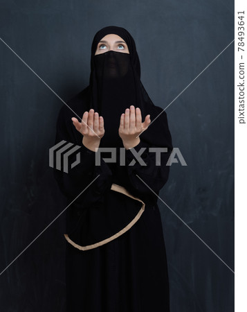 Portrait of young Muslim woman with niqab making dua 78493641
