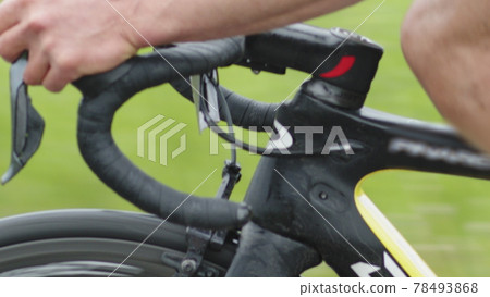 Closeup of the curved steering wheel of a road bike, the hands of a cyclist switching speed while driving on the road. Closeup of the curved steering wheel of a road bike, the hands of a cyclist switching speed while driving on the road. 78493868