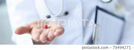 Red-white pill is on the doctor's hand 78494271