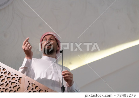 Muslims young arabic Imam has a speech on friday afternoon prayer in mosque. Muslims young arabic Imam has a speech on friday afternoon prayer in mosque. 78495279
