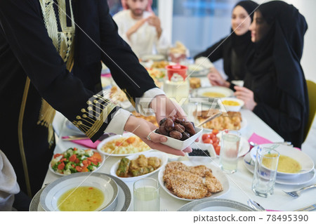 Muslim family starting iftar with dates during Ramadan 78495390