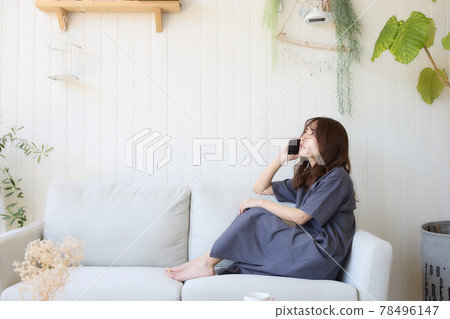 打一個電話的婦女在客廳 打一個電話的婦女在客廳 78496147