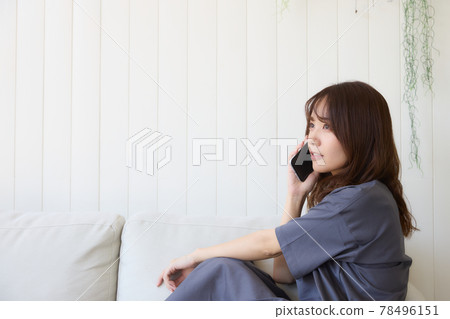 打一個電話的婦女在客廳 78496151