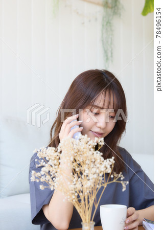 打一個電話的婦女在客廳 打一個電話的婦女在客廳 78496154