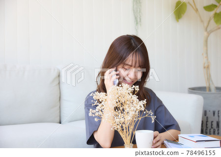 打一個電話的婦女在客廳 打一個電話的婦女在客廳 78496155
