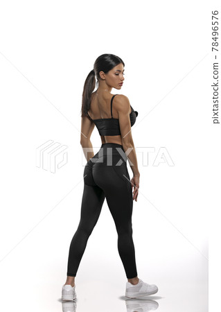 girl in black leggings and a top stay back on a white background 78496576