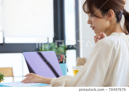 一位女士在辦公桌前使用電腦 78497676