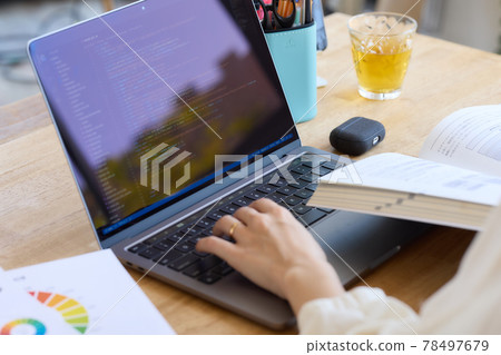 一位女士一邊在辦公桌前看參考書一邊學習 一位女士一邊在辦公桌前看參考書一邊學習 78497679