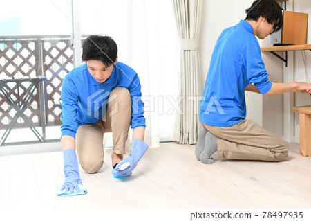 Multiple young men in cleaning work clothes cleaning in the room 78497935