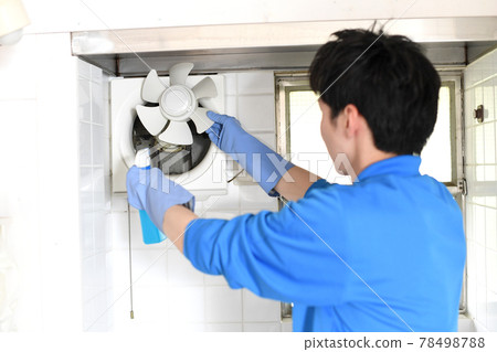一個穿著工作服的年輕人在清潔行業清洗通風扇 78498788