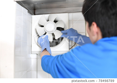 一個穿著工作服的年輕人在清潔行業清洗通風扇 78498789