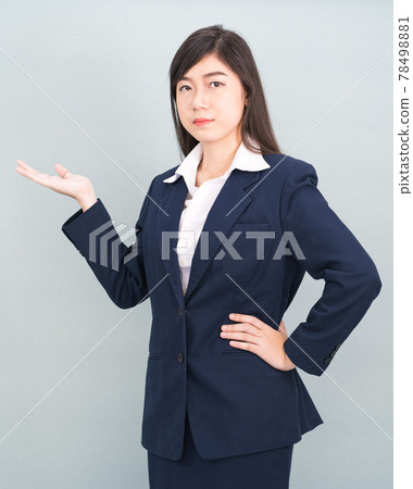 Asian woman in suit open hand palm gestures with empty space Asian woman in suit open hand palm gestures with empty space 78498881
