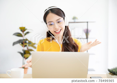 Happy young girl student studying at home sitting at the desk 78499365