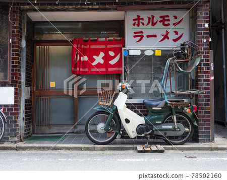 A motorcycle with a delivery machine at a ramen shop 78502160