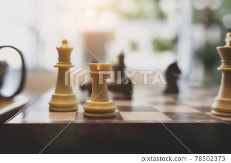 Close up view of chess board with chess pieces on wooden table. Close up view of chess board with chess pieces on wooden table. 78502373