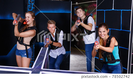 First person view of young people aiming from laser gun in dark laser tag game room First person view of young people aiming from laser gun in dark laser tag game room 78502742