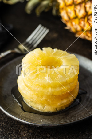 Canned sliced pineapple fruit on plate. 78502790