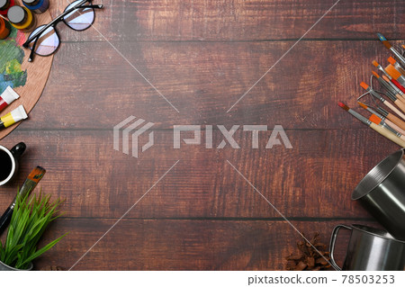 Top view of artist workspace with glasses, coffee cup, water color, paint brushes and copy space on wooden background. Top view of artist workspace with glasses, coffee cup, water color, paint brushes and copy space on wooden background. 78503253