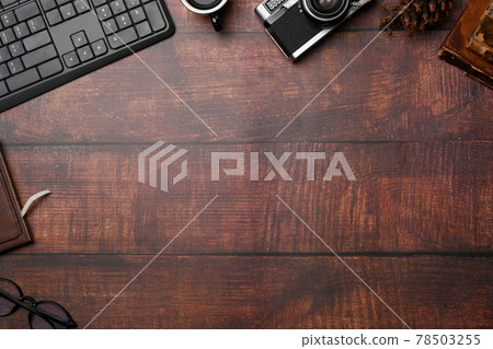 Freelancer workspace with camera, notebook, coffee cup and glasses on wooden background. 78503255