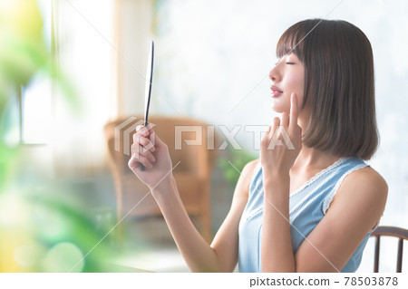 Woman looking in the mirror 78503878