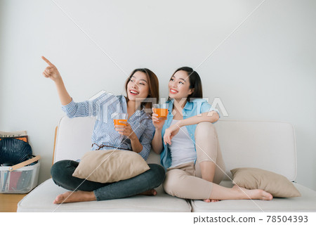 Two girlfriends having a talk on the couch  at home 78504393
