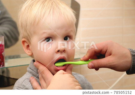 Dad and son brush their teeth in the bathroom. Father Brushing Teeth to Child 78505152