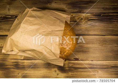 Bread packed in paper on wooden table Bread packed in paper on wooden table 78505704