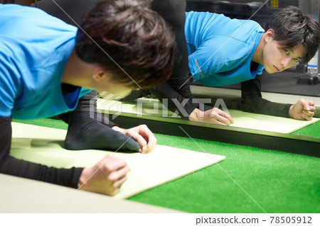 Young man stretching in front of a mirror 78505912